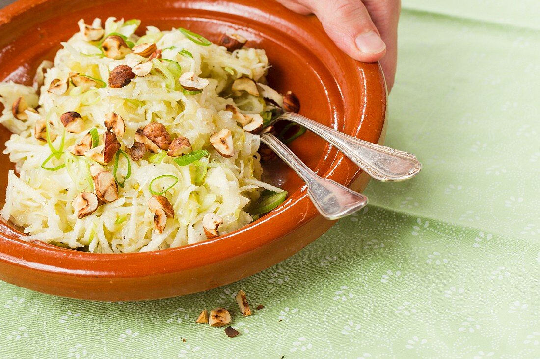 Vegan sauerkraut and raw vegetable salad with apples and hazelnuts