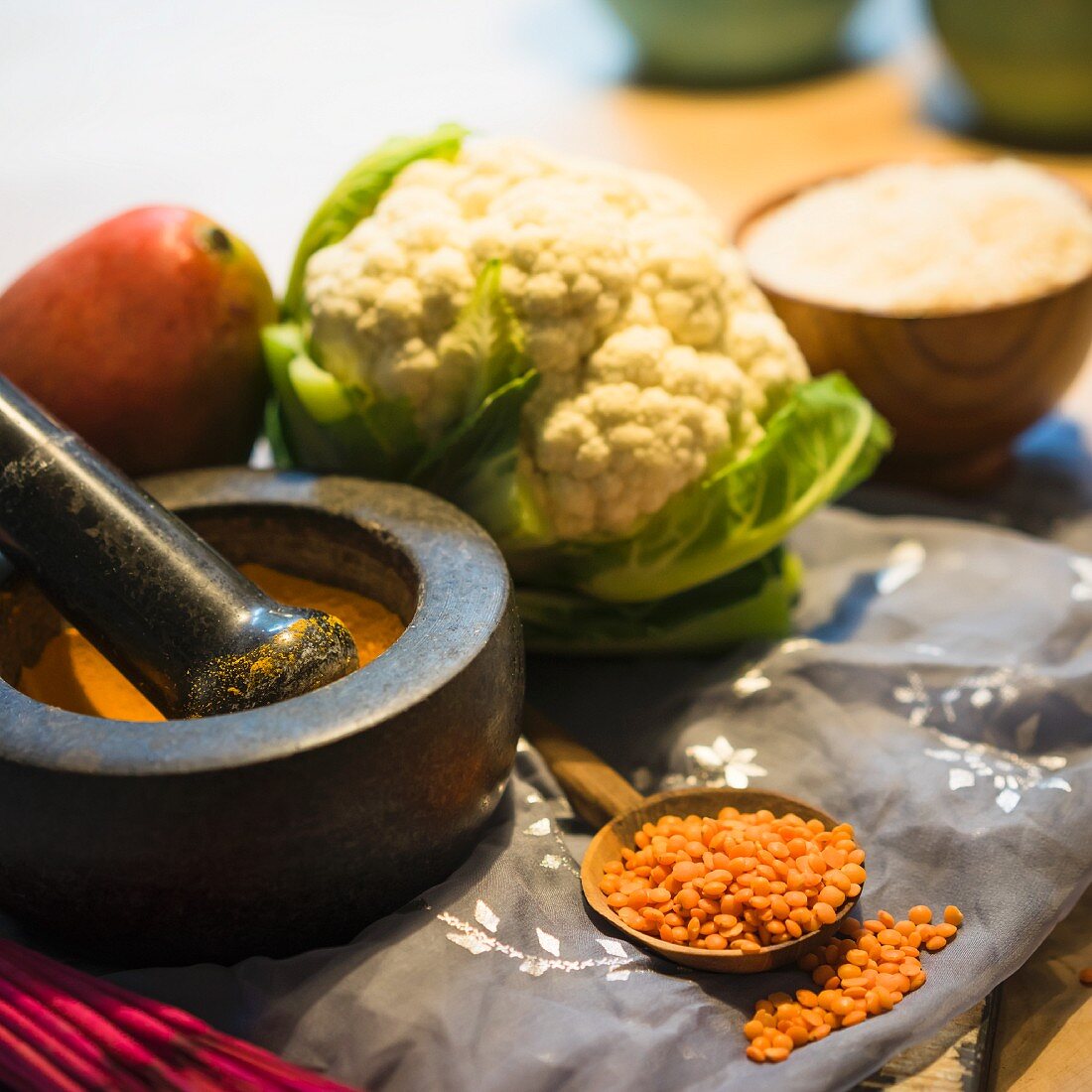 An arrangement of curry powder, lentils, mango and cauliflower