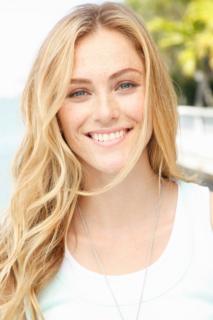 A blonde woman wearing a sleeveless white top