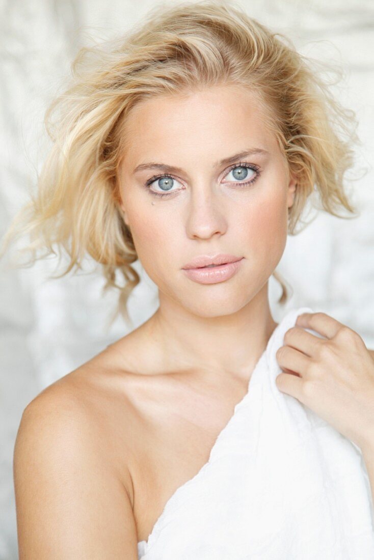 A young blonde woman wrapped in a towel