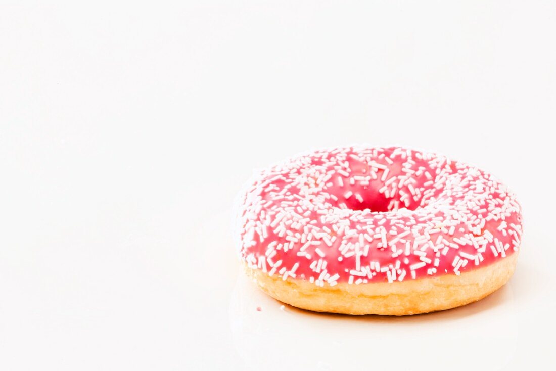 A pink doughnut with sugar sprinkles