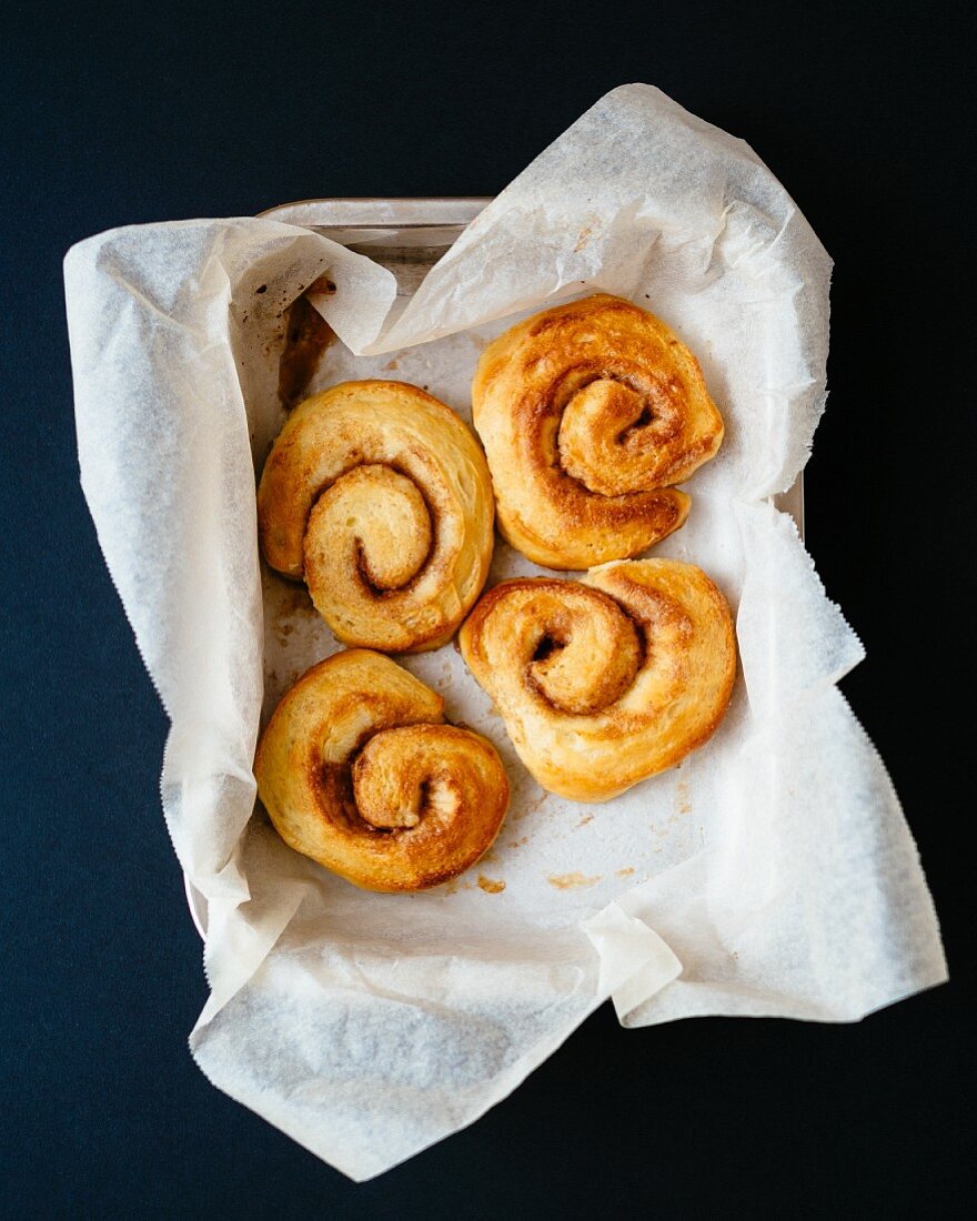 Four cinnamon buns on piece of paper