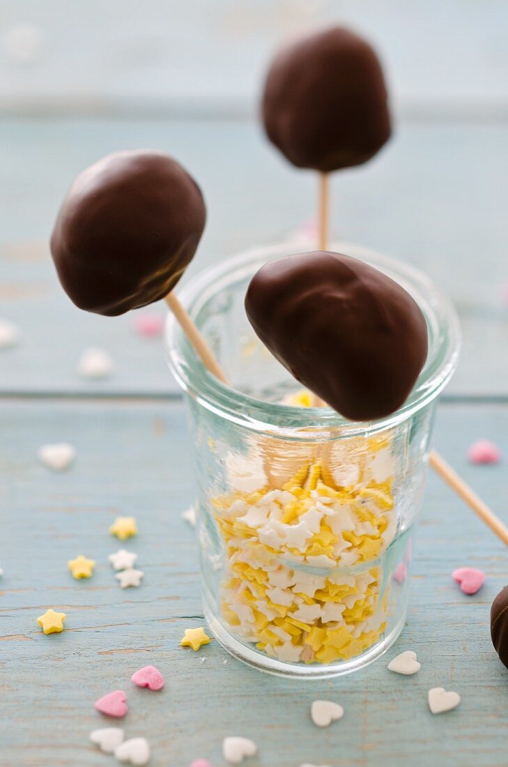 Schokoladenlollis im Glas mit Zuckersternen und -herzen