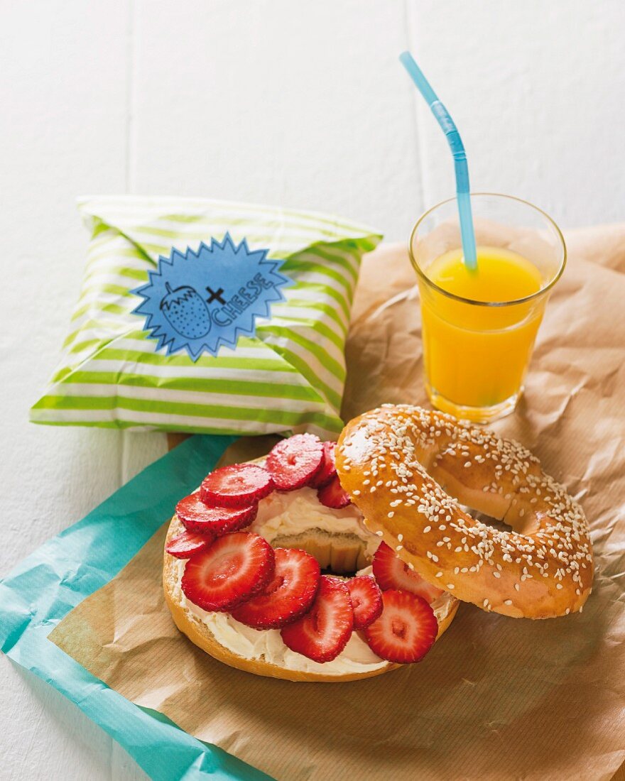 A cream cheese bagel with strawberries