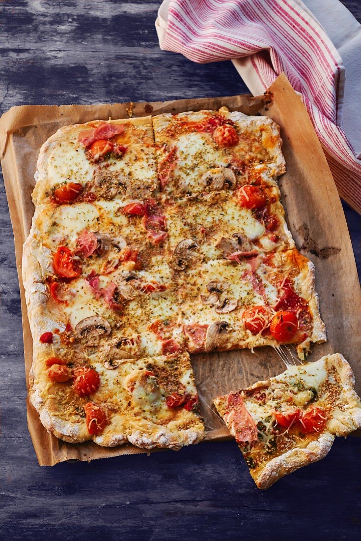 Pizza mit Schinken, Champignons und Tomaten
