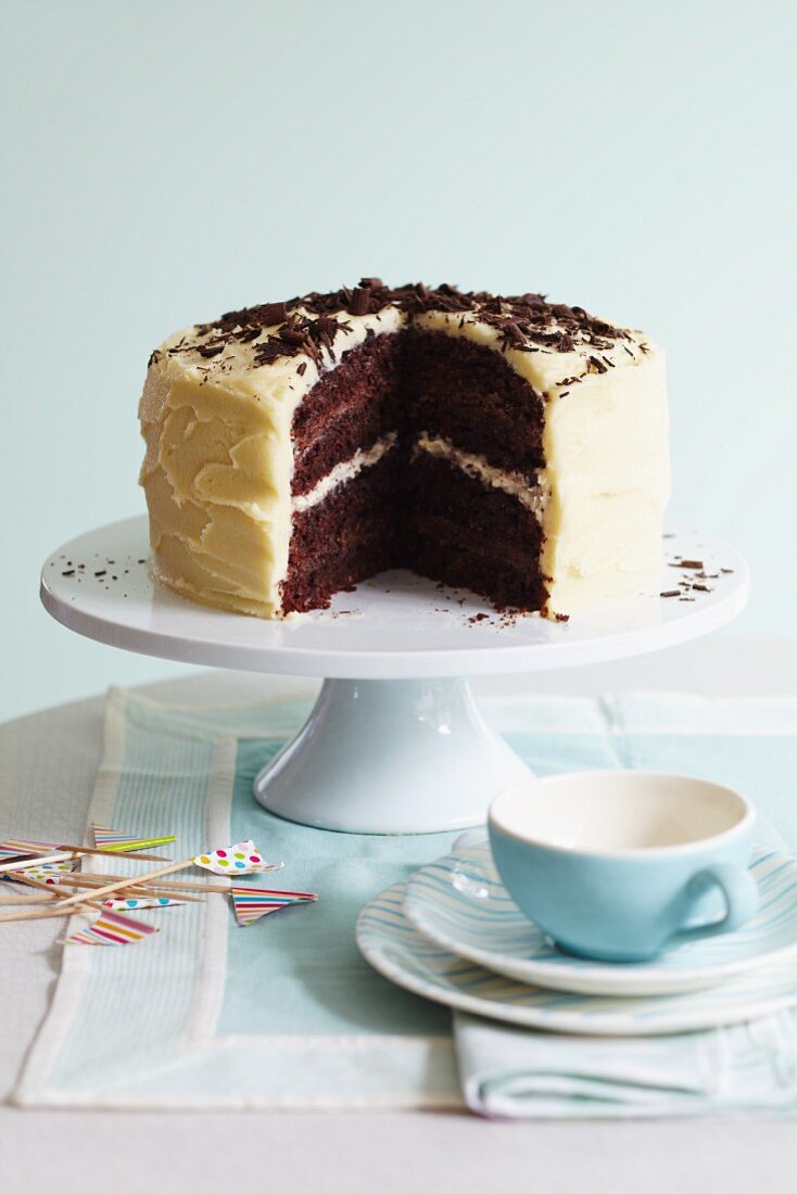 A chocolate celebration cake with a chocolate and vanilla cream filling, frosting and chocolate curls