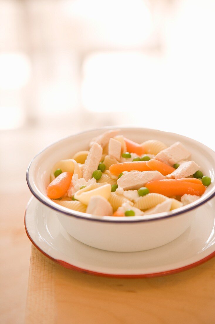 Shell pasta with chicken, carrots and peas