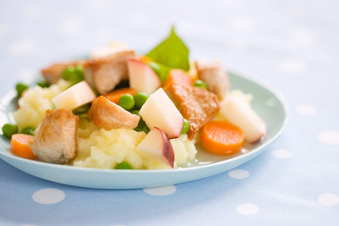 Chicken with apple, peas and carrots on mashed potatoes