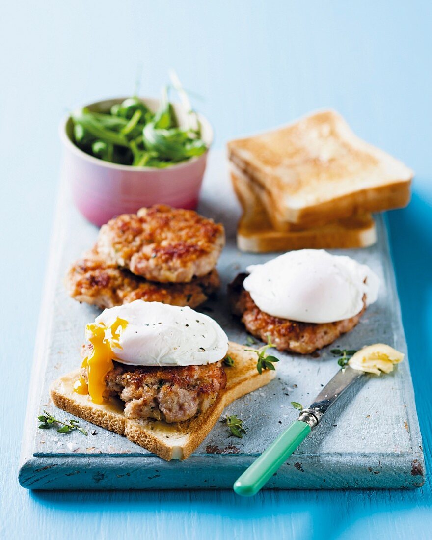 Sausage meat burgers on toast with poached eggs