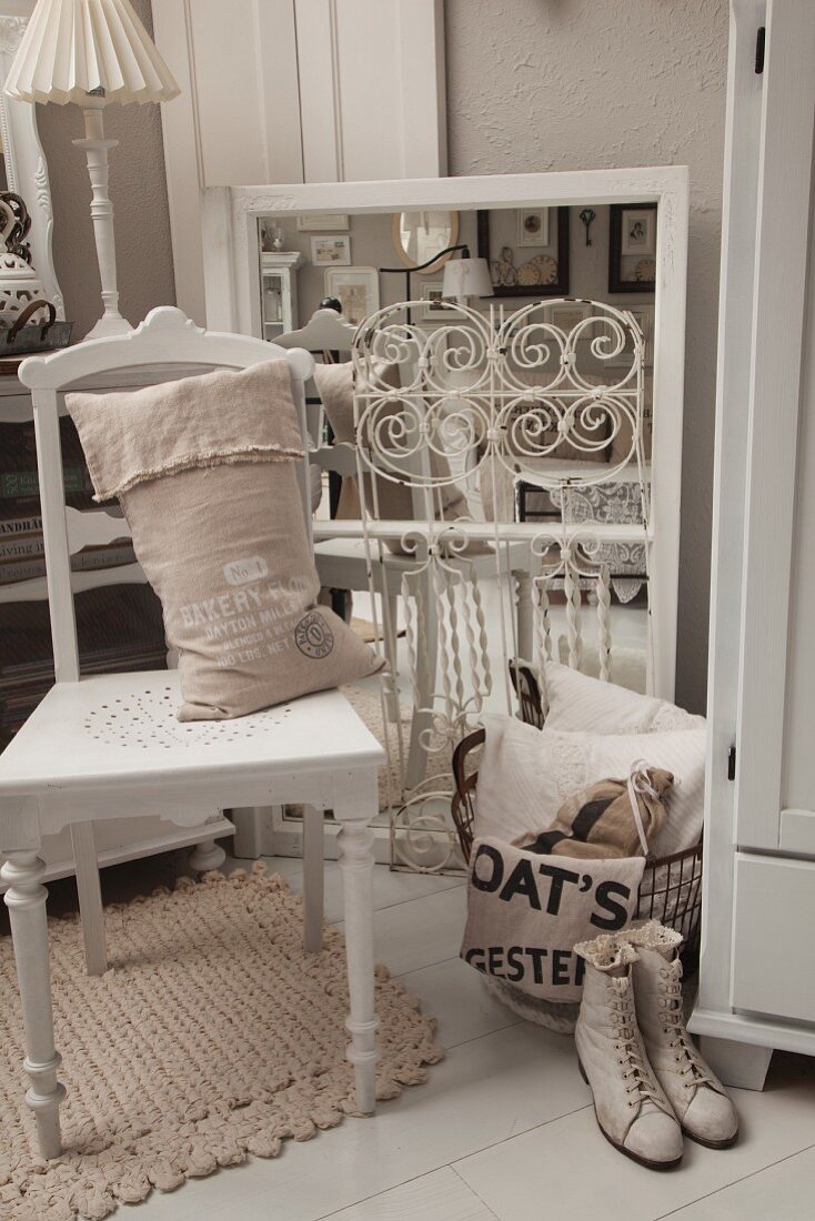 Hessian sack on white-painted kitchen chair, vintage ladies' laced boots and vintage-style flea-market finds on white-painted wooden floor