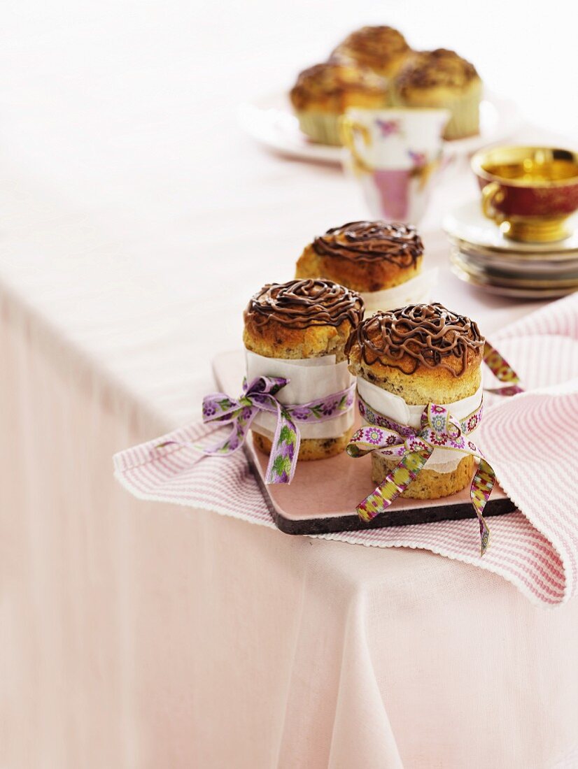 High chocolate muffins decorated with colourful bows