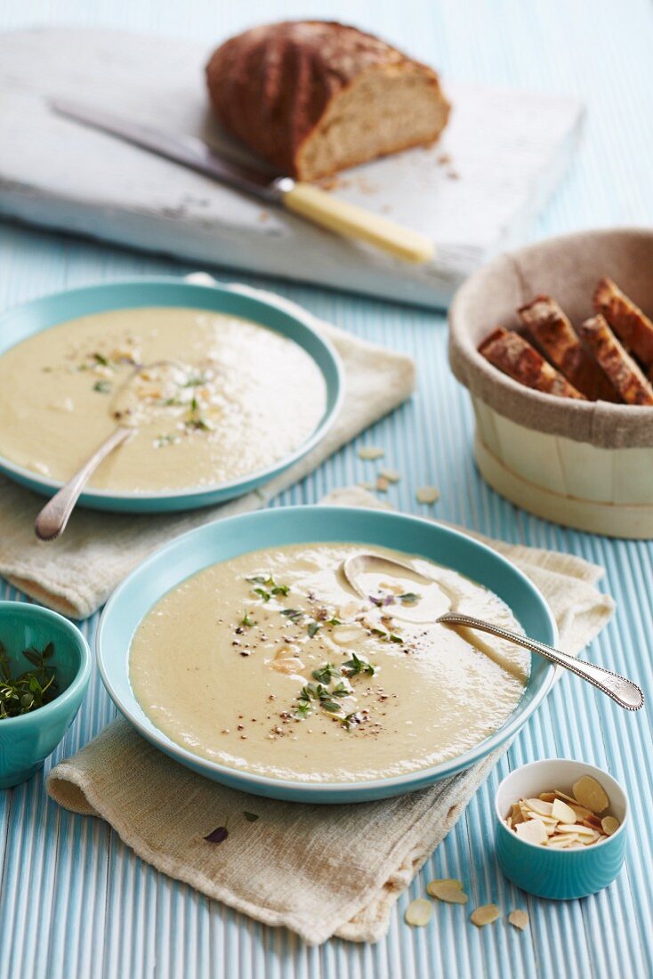 Pilzsuppe, garniert mit Thymian und Mandeln, serviert mit knusprigem Bauernbrot