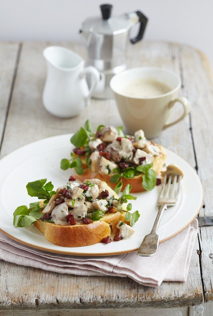 Two slices of brioche toast topped with mushrooms, tarragon and watercress