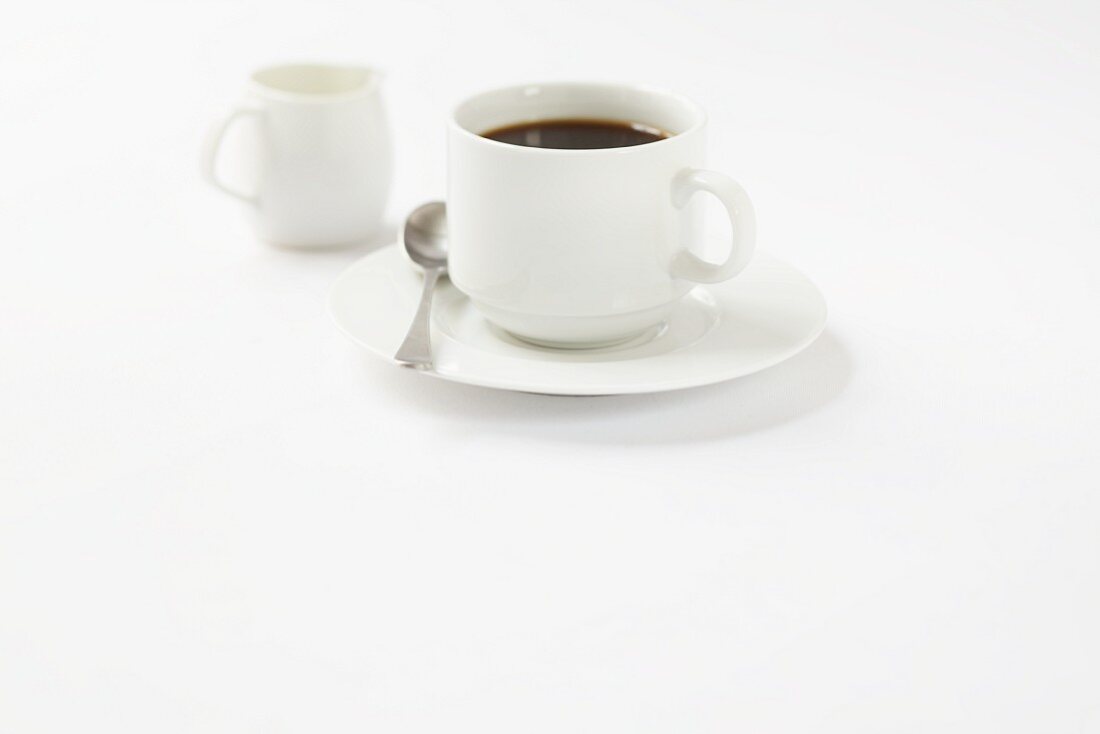 Eine Tasse schwarzer Kaffee mit Milchkännchen