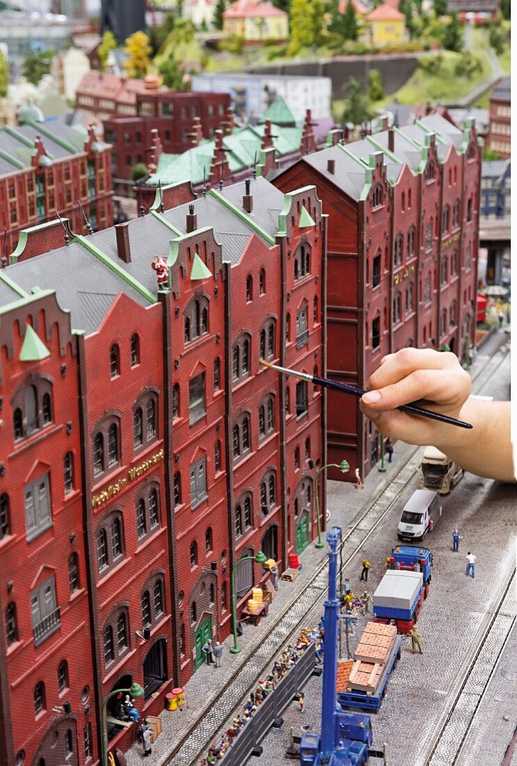 Miniatur Wunderland: a member of staff cleans the model houses of the Speicherstadt, Hamburg