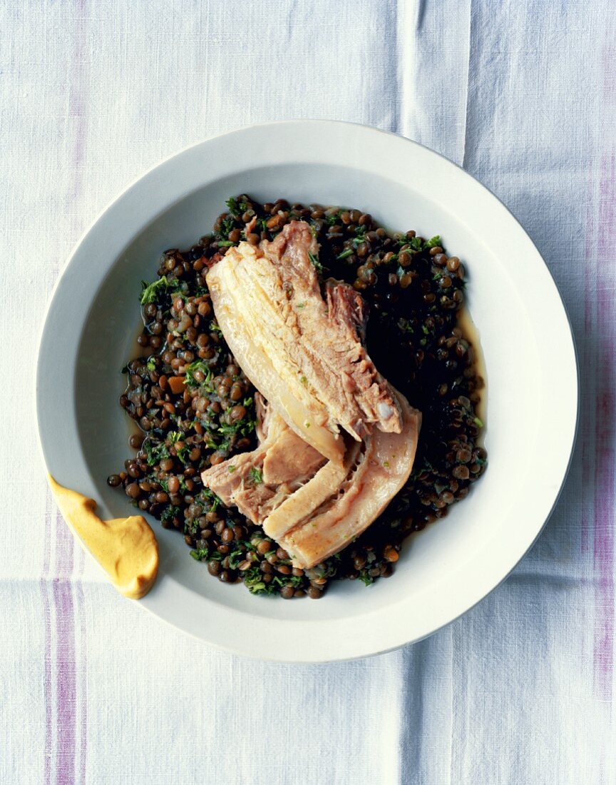 Boiled pork belly on a bed of lentils