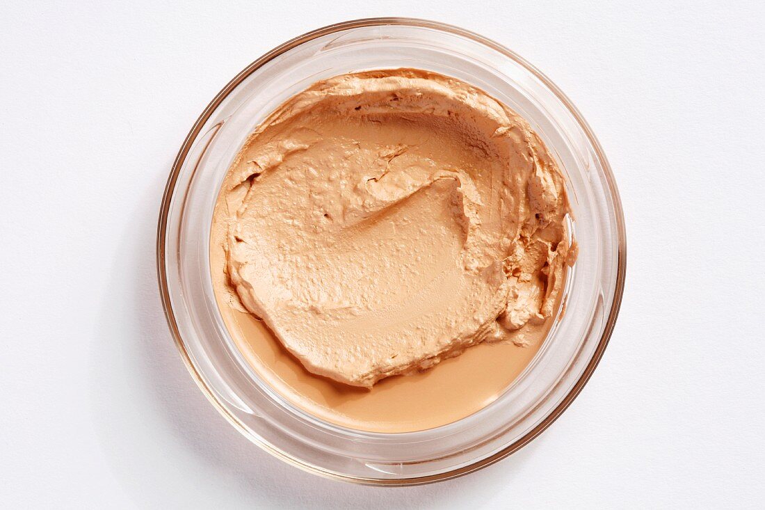 A glass jar of mousse make-up