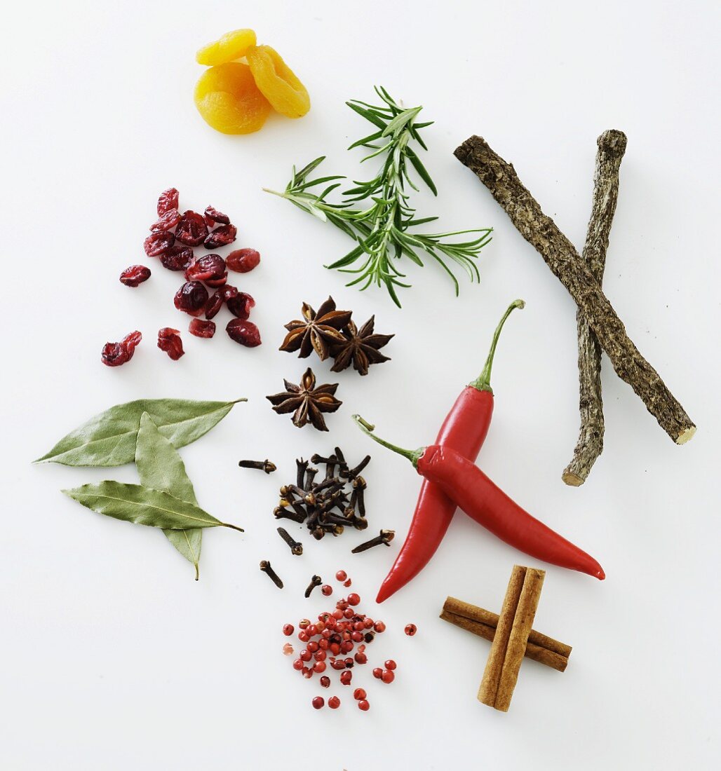 Spices, herbs and dried fruit on a white surface