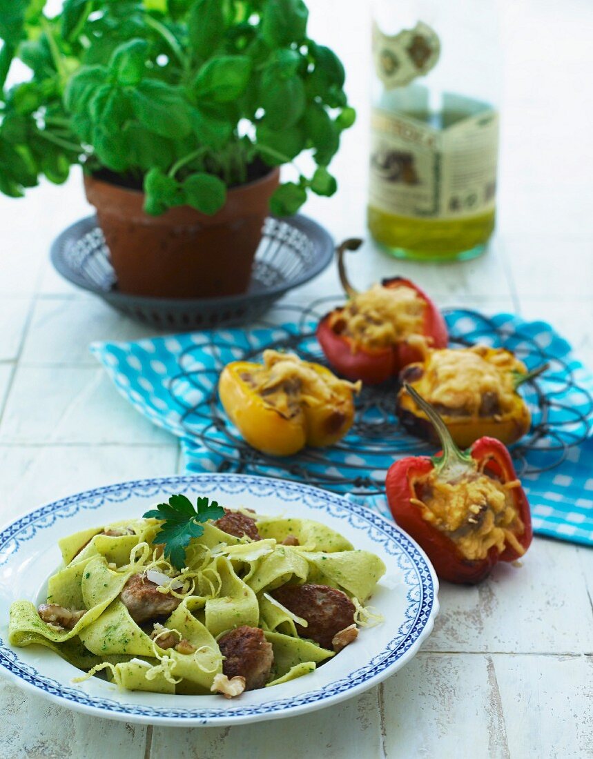 Spinach noodles with meatballs and walnuts and stuffed, oven-roasted peppers