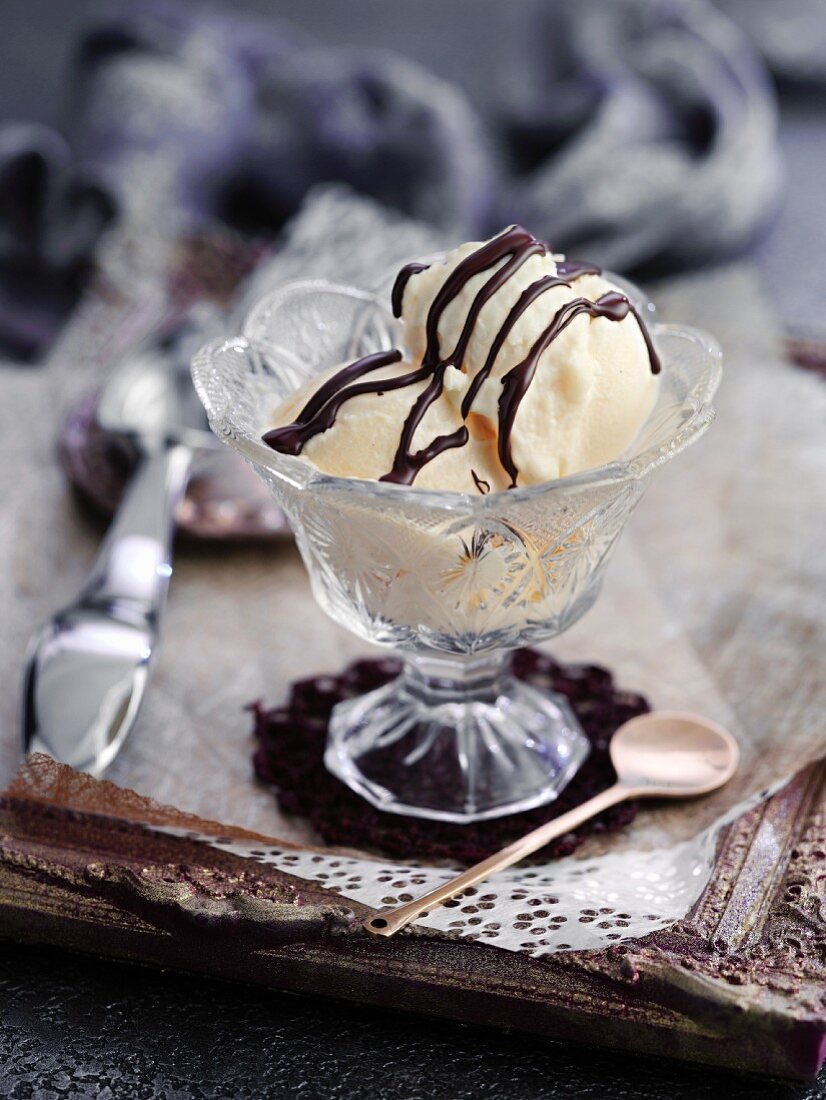 Vanilla ice cream with chocolate sauce in a crystal glass