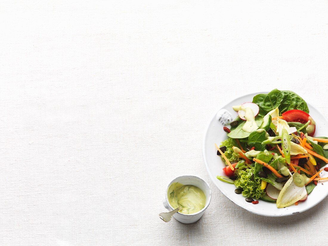 A mixed leaf salad with vegetables and a dressing