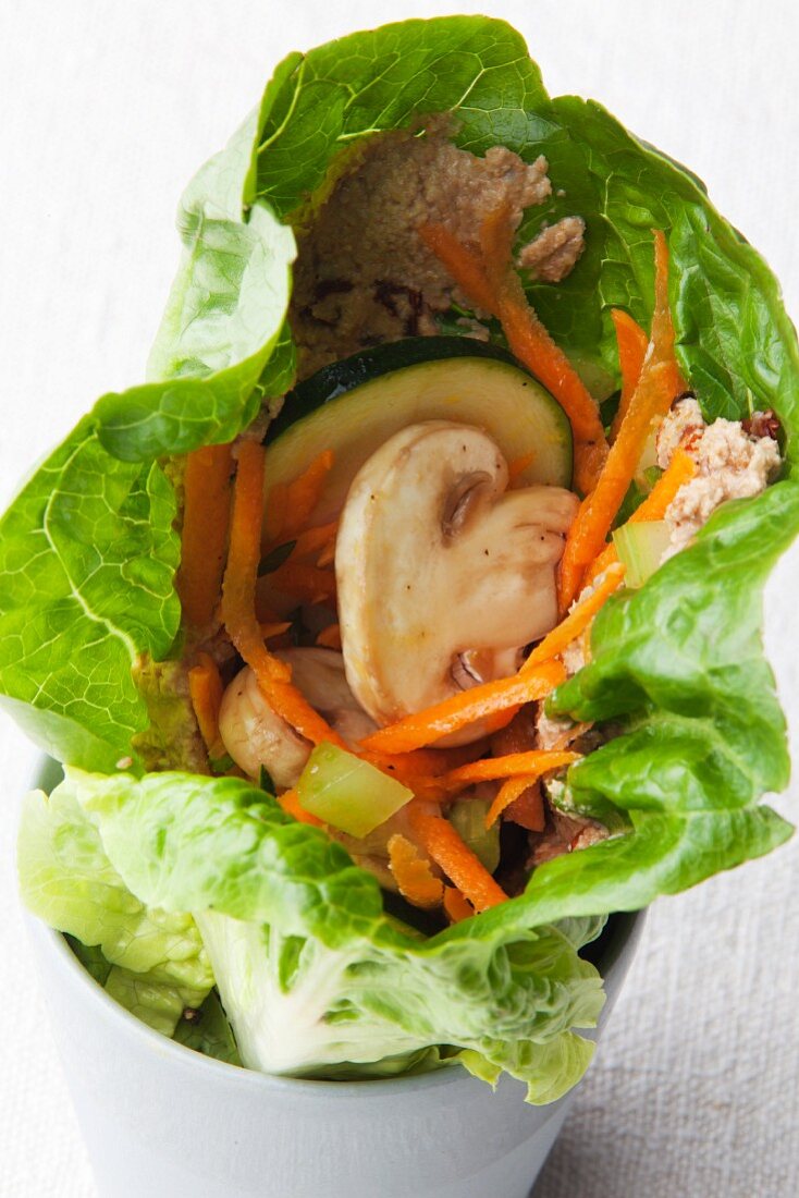 A vegan lettuce wrap with vegetables and sunflower seed cream