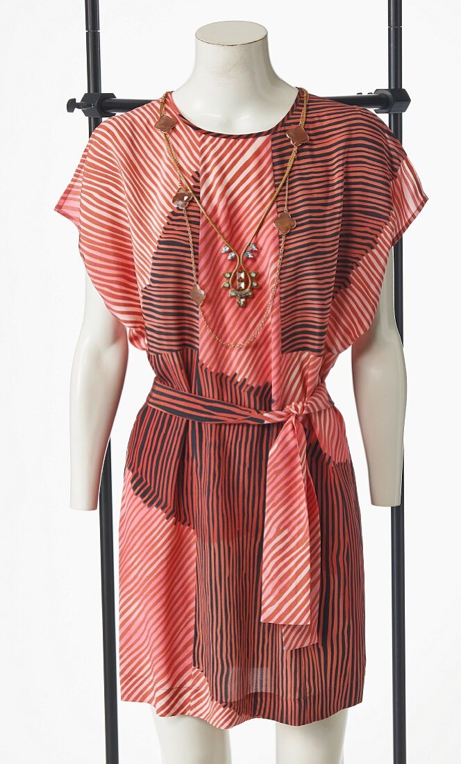 Red striped dress and costume jewellery necklace on mannequin without head
