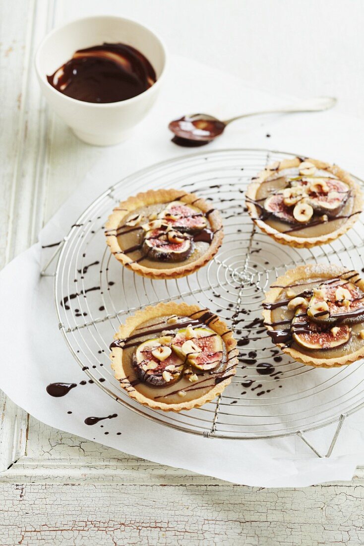 Four caramel tartlets with figs and drizzled chocolate