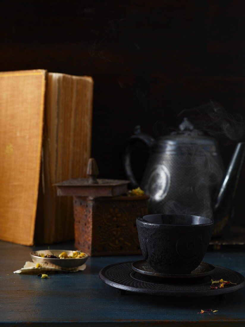 Teetasse mit Teekanne auf Holztisch