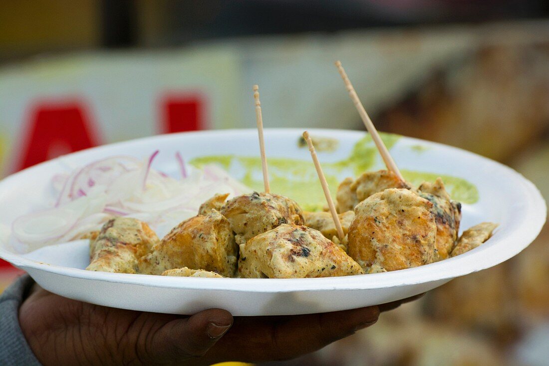 Hand hält Paneer Kebabs (Street Food aus Indien)