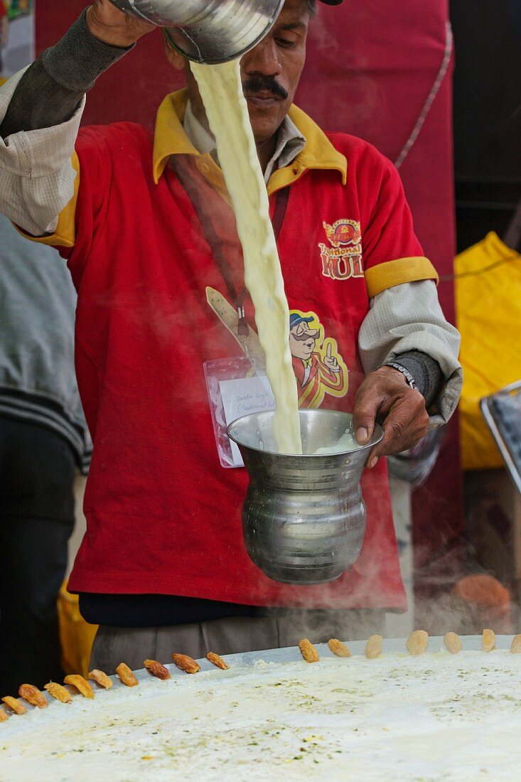 An Indian man making traditional kulfi (milk ice cream, India)
