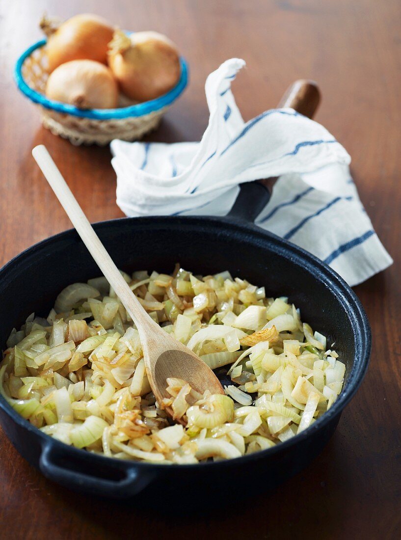 Angedünstete Zwiebeln in einer Eisenpfanne