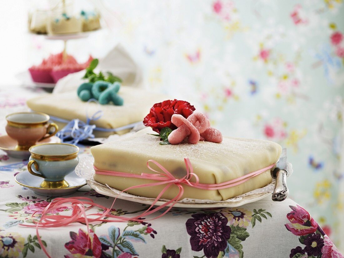 Two cakes for a pair of twins decorated with pink and light blue marzipan dummies