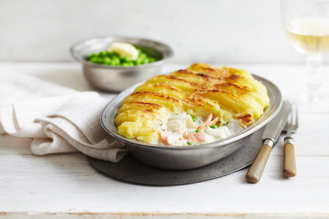 Whiting and salmon pie with a mashed potato topping served with peas