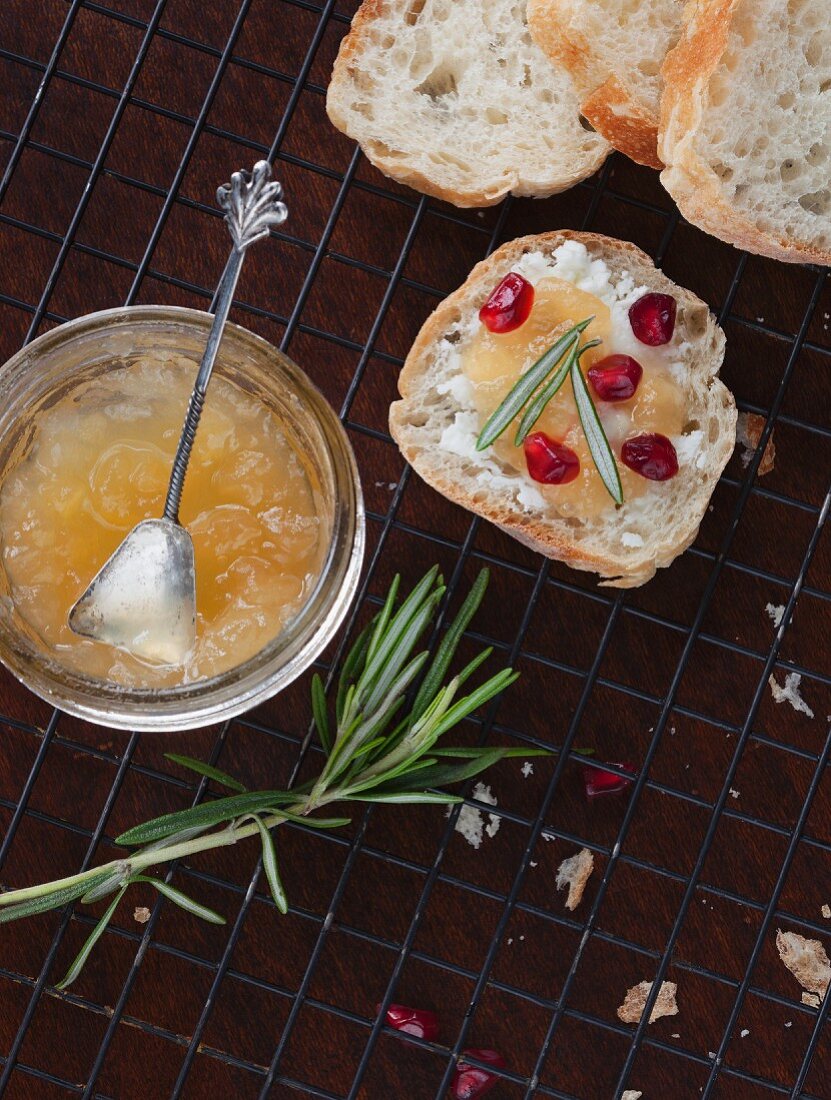 Homemade pear jam on a slice of bread with rosemary and pomegranate seeds