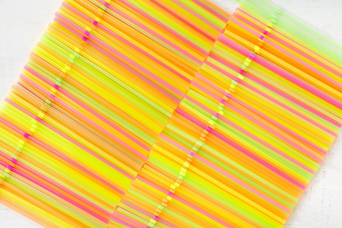 Two rows of colourful drinking straws (seen from above)