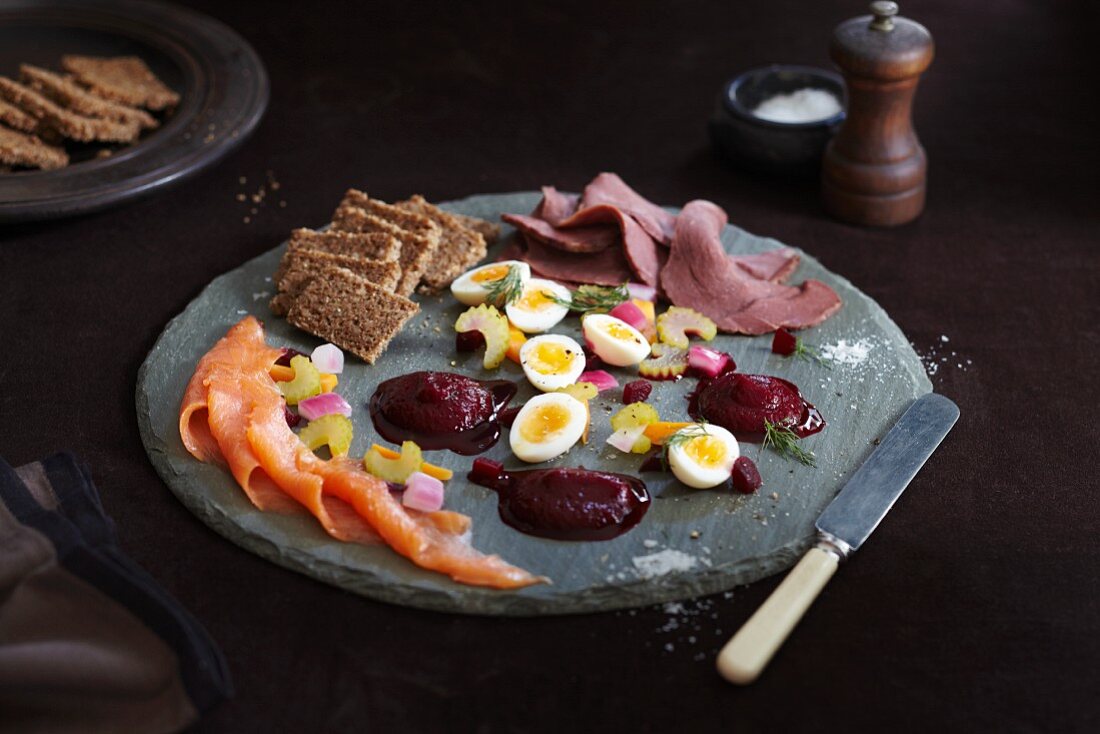 Skandinavischer Vorspeisenteller mit Räucherlachs, Rote-Bete-Püree, Roggenbrot, gekochten Eiern und kalten Rindfleischscheiben