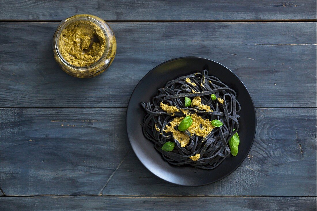 Black squid ink pasta with basil pesto and fresh basil leaves