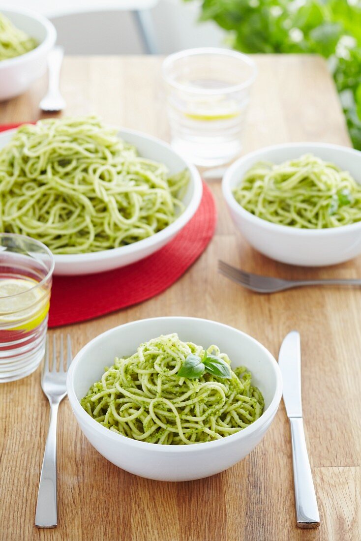 Spaghetti with basil pesto on a dining table