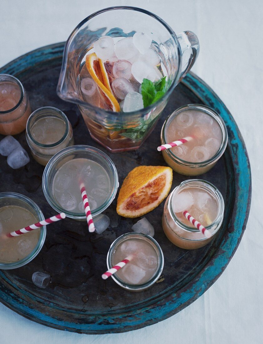 Glasses and a jug of quince lemonade on a wooden tray