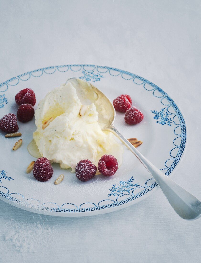 Ricotta cream with raspberries on an old plate with a spoon