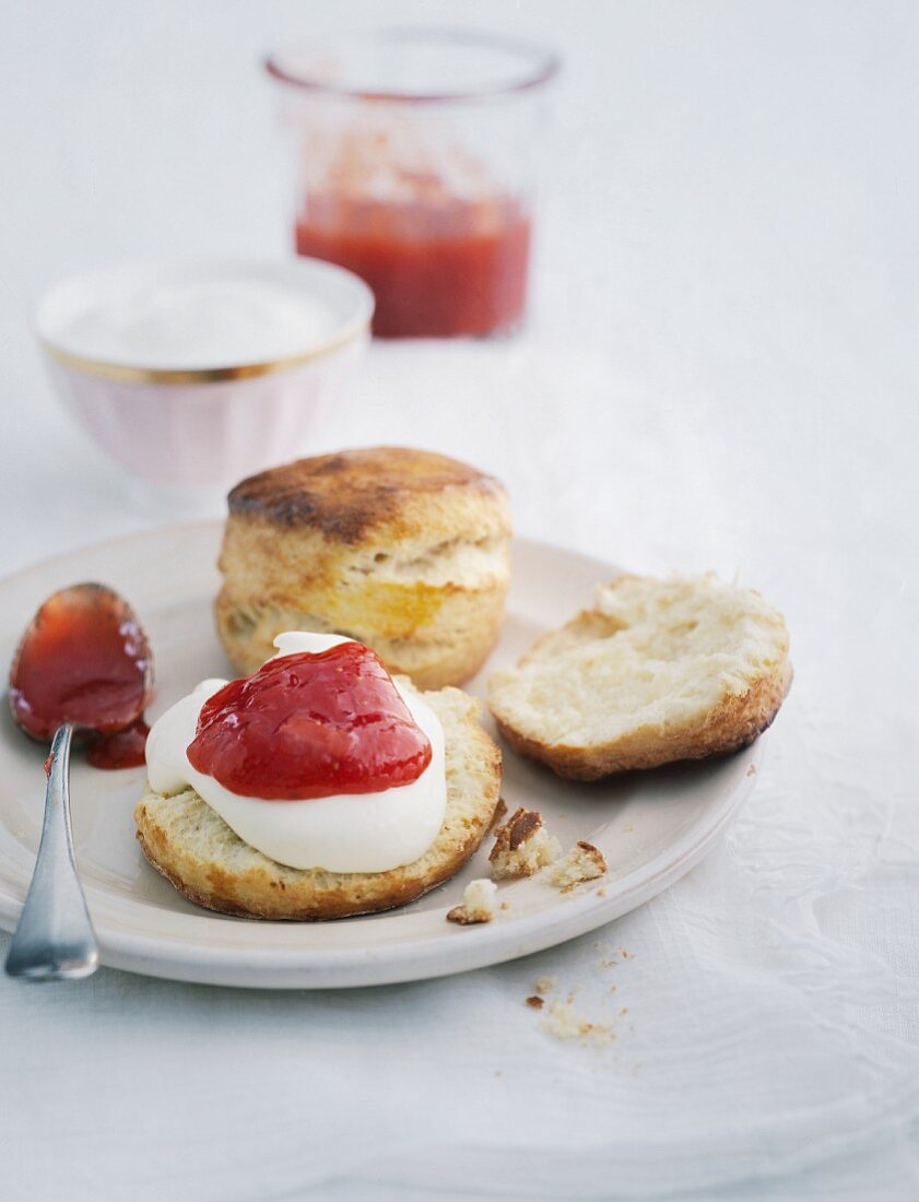 Scones mit Marmelade auf Porzellanteller mit Löffel