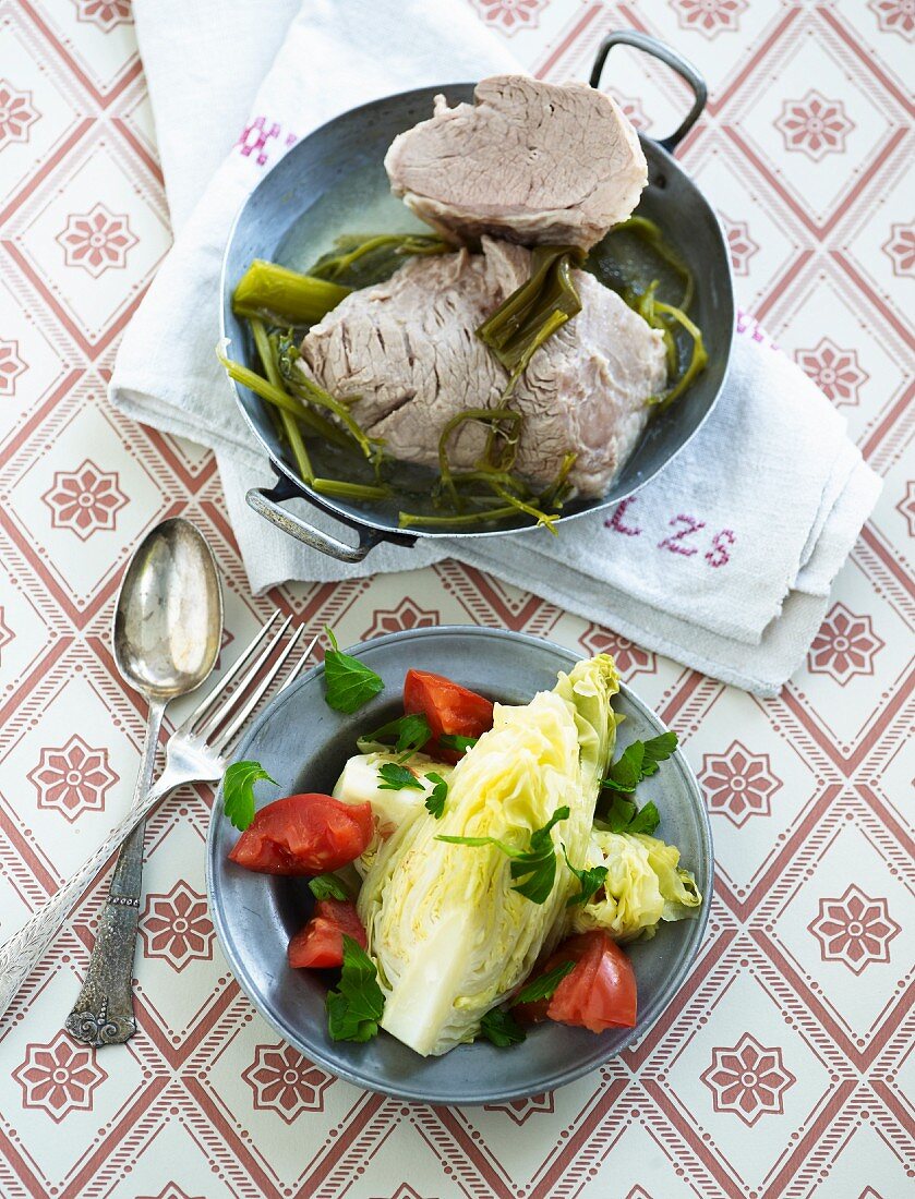 Boiled beef on a bed of spinach and a wedge of iceberg lettuce with vinaigrette