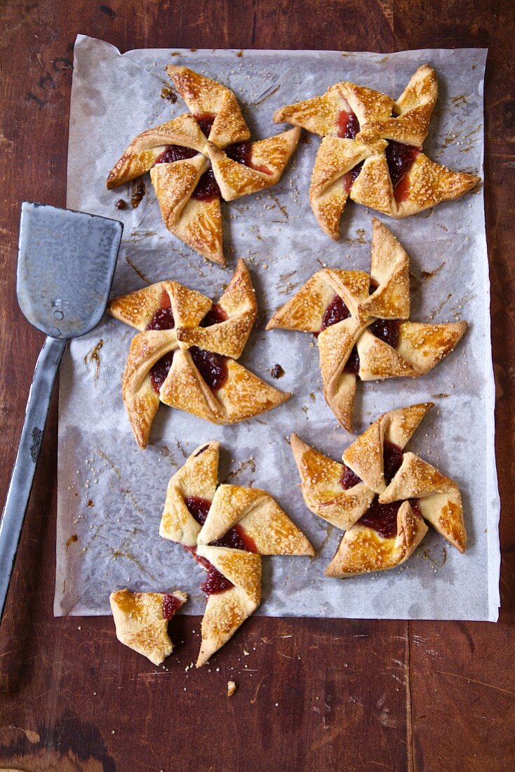 Raspberry jam pinwheel pastries on baking paper