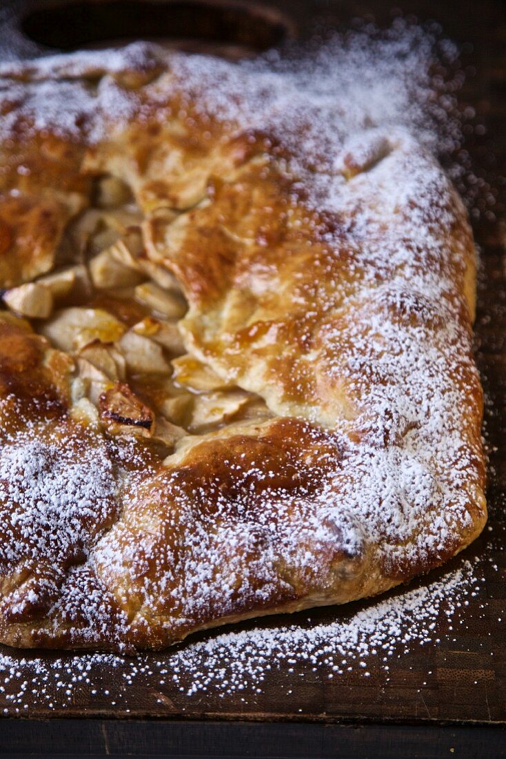 Apfeltarte mit Puderzucker auf Schneidebrett