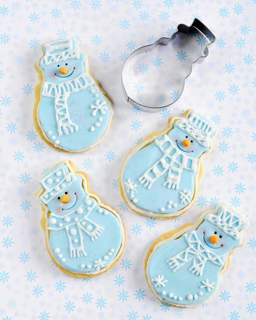 Snowman shaped Christmas biscuits with blue and white icing