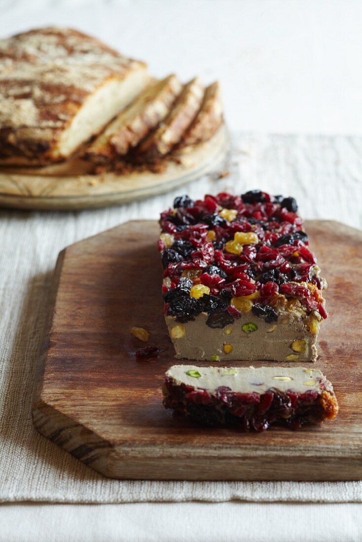 Pâté with cranberries, raisins and sultanas with sliced bread in the background