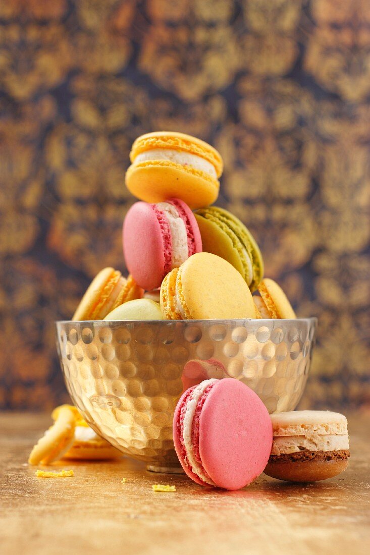 Colourful macaroons, some in a metal bowl