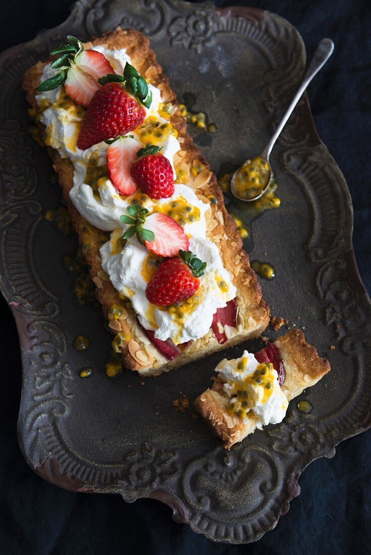 Frangipane cake with strawberries and passion fruit sauce, sliced