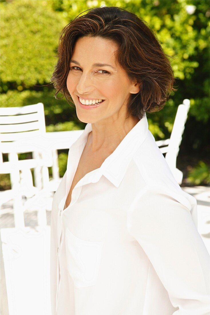 A brunette woman wearing a white blouse